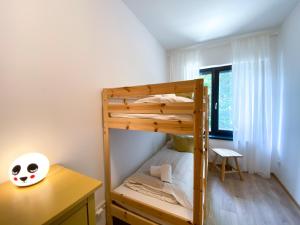 a bunk bed in a room with a desk and a bed at Apartment Aria Velden in Velden am Wörthersee