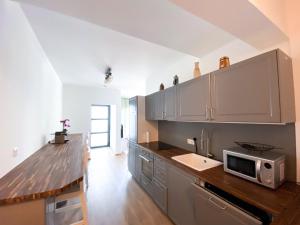 eine Küche mit einer Arbeitsplatte und einer Mikrowelle in der Unterkunft Apartment Aria Velden in Velden am Wörthersee