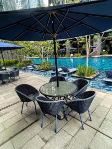 a table and chairs with an umbrella next to a pool at STAR RESIDENCE KLCC in Kuala Lumpur
