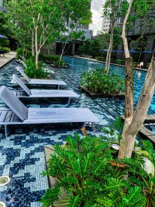 a pool with chaise lounges in a resort at STAR RESIDENCE KLCC in Kuala Lumpur