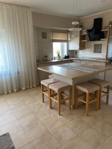 eine Küche mit einem großen Holztisch und Stühlen in der Unterkunft Сонячне Закарпаття in Poljana