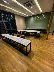einen Konferenzraum mit Tischen, Stühlen und einer Tafel in der Unterkunft STAR RESIDENCE KLCC in Kuala Lumpur