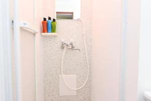 a shower with a hose attached to a wall in a bathroom at HEIGHTS N7 in Kita-rokujō