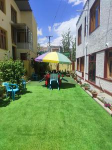 a patio with a umbrella and chairs on the grass at The Mir Villa Ladakh in Leh