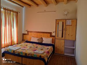 a bedroom with a bed with a wooden headboard at The Mir Villa Ladakh in Leh