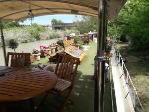 a patio with a table and chairs next to a river at Peniche Caroline in Capestang