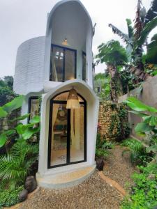 a white house with a window in a yard at OMA WATU DOME VILLAS in Pacitan