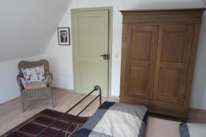 a bedroom with a bed and a cabinet and a chair at Wohnen am Dehnthof Haus 2 in Kappeln