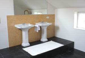 a bathroom with two sinks and a mirror at Wohnen am Dehnthof Haus 2 in Kappeln