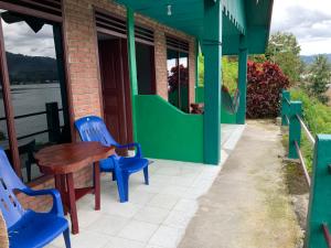a table and chairs sitting outside of a building at Mario Lakeside Apartments in Tuktuk Siadong