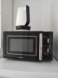 a black microwave with a coffee pot on top of it at BELLE VIEW SINAIA in Sinaia