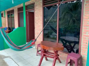 een patio met een hangmat en een tafel en stoelen bij Mario Lakeside Apartments in Tuk Tuk