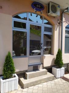 a front door of a store with two potted trees in front at Sky is the limit * Novi Sad * in Novi Sad