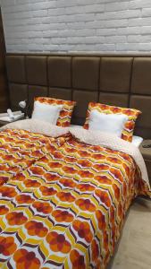 a bedroom with a bed with a colorful comforter and pillows at Sky is the limit * Novi Sad * in Novi Sad