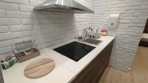 a kitchen with a sink and a white brick wall at Sky is the limit * Novi Sad * in Novi Sad