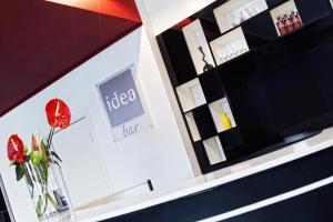 a vase with a red flower on a shelf in a store at Idea Hotel Milano Malpensa Airport in Case Nuove