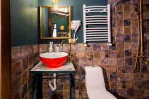 ein Badezimmer mit einem roten Waschbecken und einem WC in der Unterkunft Vorontsoff Inn Boutique Hotel in Tbilisi City