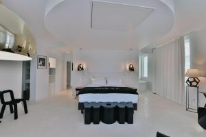 a white bedroom with a large bed and a table at Le Meez in Carcassonne