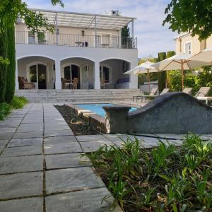 a house with a swimming pool in front of it at Maison d'Ail Guest House in Franschhoek