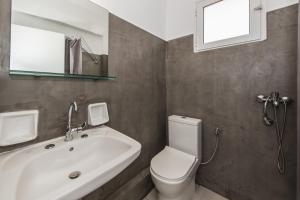 a bathroom with a white toilet and a sink at Odysseas Studios in Lithakia