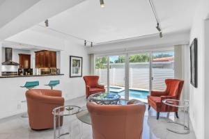 uma sala de estar com cadeiras e uma mesa de vidro em Sandcastles & Sunshine at Towering Palms of Wilton Manors residence em Fort Lauderdale