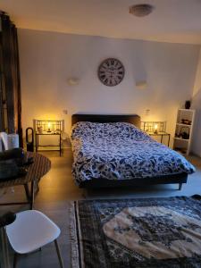 a bedroom with a bed and a clock on the wall at Le clos Fleury Cluny in Cluny