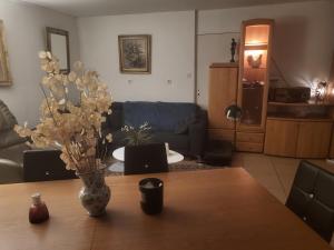 a living room with a vase on a wooden table at Le clos Fleury Cluny in Cluny