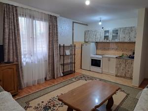 a living room with a table and a kitchen at Apartman Lara 2 in Foča
