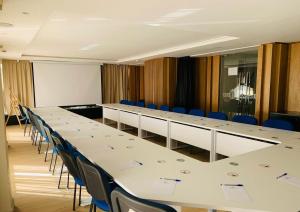 uma sala de conferências com mesas brancas e cadeiras azuis em Imperial Boutique Hotel Rabat em Rabat
