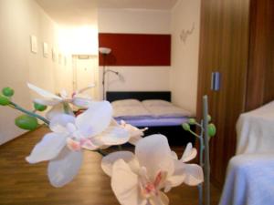 ein Zimmer mit einem Bett und weißen Blumen darin in der Unterkunft Apartment Beethoven in Regensburg