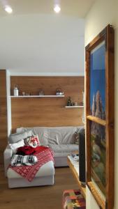 un salon avec un canapé blanc et une télévision dans l'établissement Relax Home Fie' allo Sciliar - Alpe di Siusi Val Gardena, à Fiè