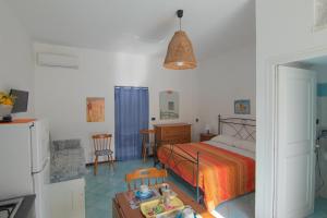 um quarto com uma cama, uma mesa e cadeiras em Ponza Holiday Homes - Santa Maria em Ponza
