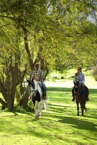 un hombre y una mujer montando caballos en un parque en Rio Sagrado, A Belmond Hotel, Sacred Valley, en Urubamba