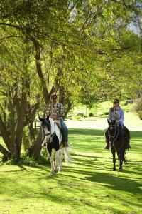 a man and a woman riding horses in a park at Rio Sagrado, A Belmond Hotel, Sacred Valley in Urubamba