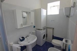 uma casa de banho branca com um lavatório e um WC em Ponza Holiday Homes - Santa Maria em Ponza
