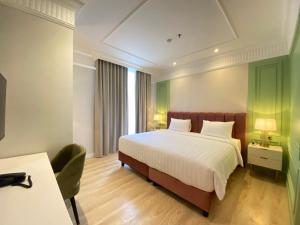 a hotel room with a bed and a desk at Maia Hotel Jakarta in Jakarta