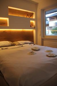 a large white bed in a room with a window at Relax Home Fie' allo Sciliar - Alpe di Siusi Val Gardena in Fiè