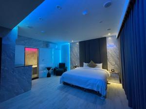 a bedroom with a large bed with blue lighting at MY Motel in Mingjian