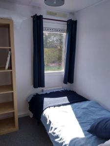 Habitación pequeña con cama y ventana en Family friendly rural lodge, en Truro