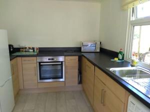 a kitchen with a sink and a stove at Family friendly rural lodge in Truro