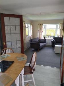 a living room with a table and chairs and a couch at Family friendly rural lodge in Truro