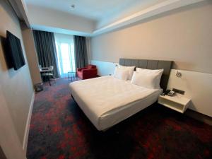 a hotel room with a large bed and a chair at SPARK HOTEL RESIDENCE KONYA in Yazır