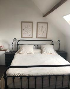 a bed in a bedroom with two pictures on the wall at Ancien Relais de Poste The Old Post Office in Saint-Martial-dʼAlbarède