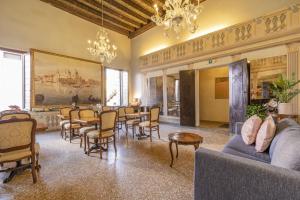 a living room with tables and chairs and a painting at Residenza Centopietre - Dorsoduro in Venice