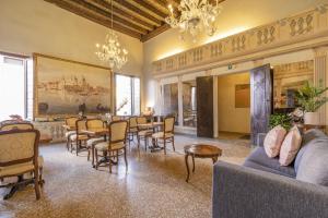 salon ze stołami, krzesłami i obrazem w obiekcie Residenza Centopietre - Dorsoduro by Wonderful Italy w Wenecji