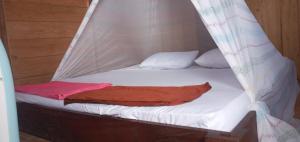 a bed with white sheets and a red blanket at Arborek Diving Homestay R4 in Besir