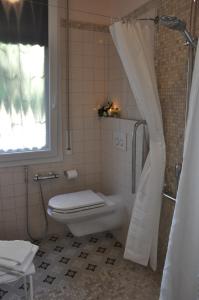 a bathroom with a toilet and a shower with a window at Casa Ardizzoni in Bologna