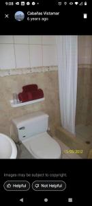 a picture of a bathroom with a toilet and a shower at Hostal Cabañas Vistamar in Crucita