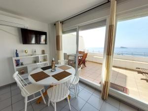 a dining room with a table and a view of the ocean at Villamarina dúplex en primera línea de mar - Fincas Arena in Benidorm