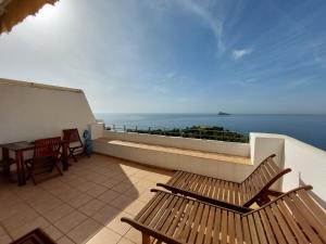 a balcony with two wooden benches and the ocean at Villamarina dúplex en primera línea de mar - Fincas Arena in Benidorm